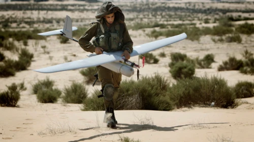 An Israeli soldier carries an unmanned aerial vehicle during a training drill at the Tze'elim army base on Aug. 5, 2013. Photo by Miriam Alster/Flash90.