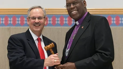 Click photo to download. Caption: The ceremonial passing of the gavel from outgoing United Methodist Church (UMC) Council of Bishops president Bishop Warner H. Brown, Jr. (at right) to the council's new president, Bishop Bruce R. Ought, during the UMC's quadrennial general conference in Portland, Ore., in May 2016. Credit: Mike DuBose/United Methodist News Service via Facebook.