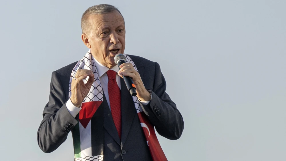 Turkish President Recep Tayyip Erdogan wears a scarf with both Turkish and Palestinian flags as he addresses a rally organized by the AKP party in solidarity with the Palestinians in Gaza, in Istanbul on Oct. 28, 2023. Photo by Yasin Akgul / AFP via Getty Images.