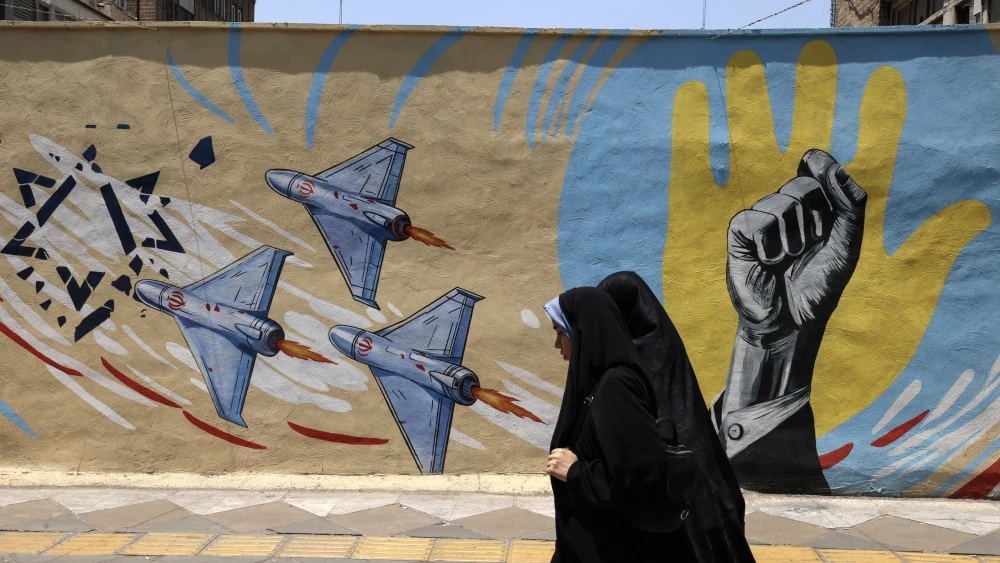 Iranian women walk past an anti-U.S. and anti-Israeli mural in Tehran, June 3, 2026. Photo by Atta Kenare/AFP via Getty Images.
