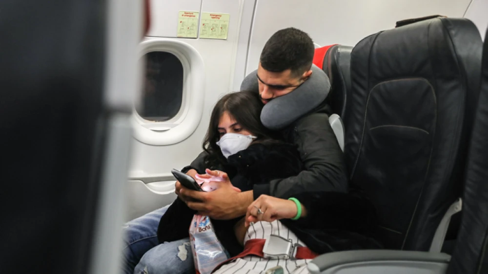 A woman wears a face mask for fear of coronavirus infection, on a flight from Israel to Italy on Feb. 21, 2020. Photo by Nati Shohat/Flash90.