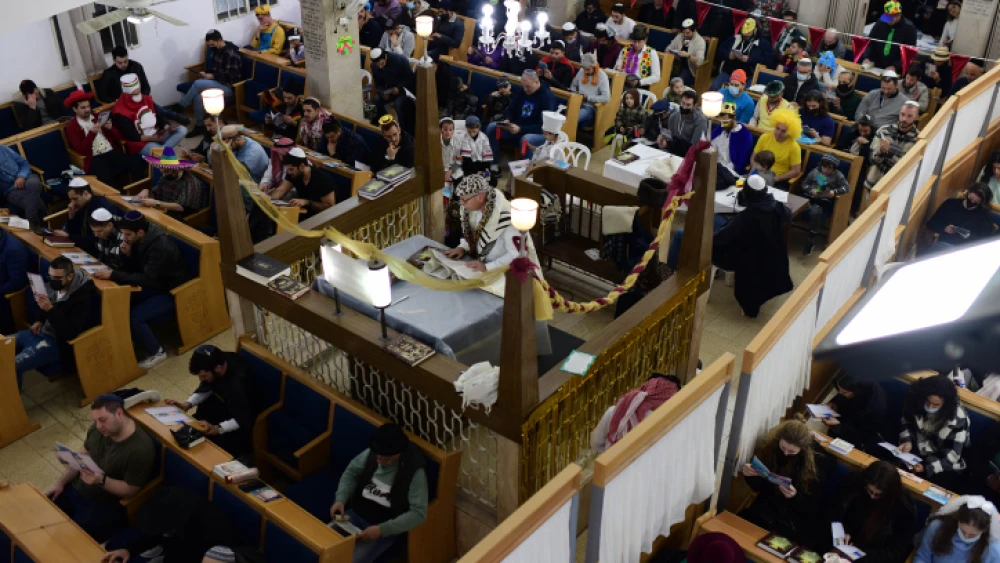 Israeli Jews read Megillat Esther (the Book of Esther) on Purim at the Gvurat Israel Synagogue in Tel Aviv, March 16, 2022. Photo by Tomer Neuberg/Flash90.