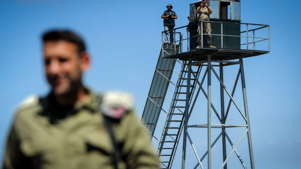 A Lebanese soldier and a Hezbollah gunman gaze into Israel from a watchtower on the border near Rosh Hanikra, Sept. 5, 2018. Photo by Basel Awidat/Flash90.