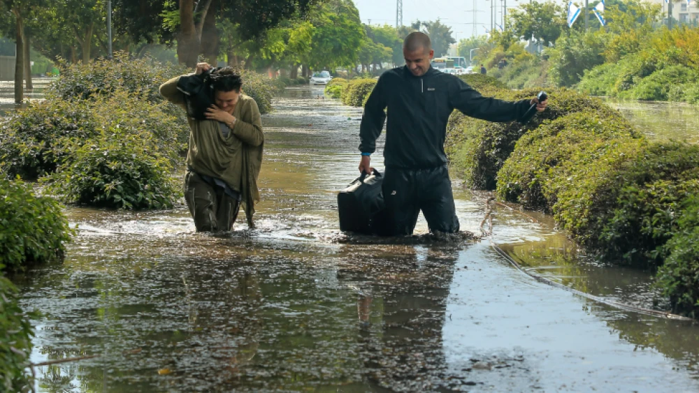 People try to wade through a flooded street after heavy rains in the southern Israeli city of Ashkelon on Nov. 9, 2015. Photo by Edi Israel/Flash90.