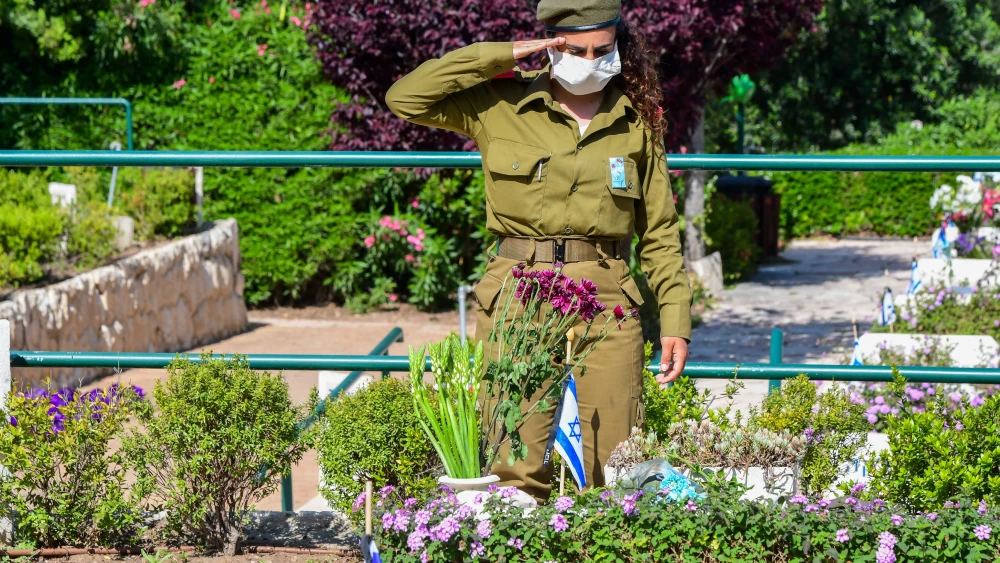 An Israeli soldier pays her respects at the Kiryat Shaul Military Cemetery as Israel marks Memorial Day for Fallen Soldiers and Victims of Terror on April 28, 2020. Photo by Avshalom Sassoni/Flash90.