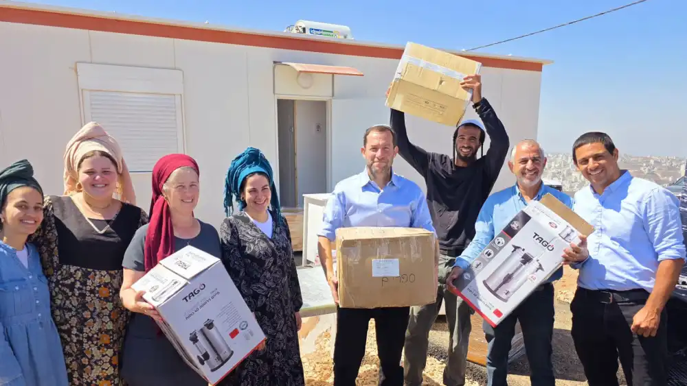 Samaria Regional Council head Yossi Dagan helps founding residents unload appliances after they moved into the new community of Ebal on Mount Ebal in Samaria, July 16, 2026. Credit: Roi Hadi.