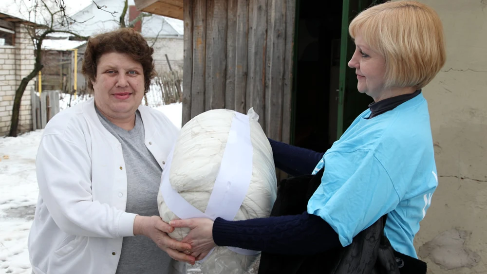 Warm bedding is delivered to Svetlana M. in Babruysk, Belarus, from a representative of the American Jewish Joint Distribution Committee’s Hesed Social Welfare Center. Credit: JDC.