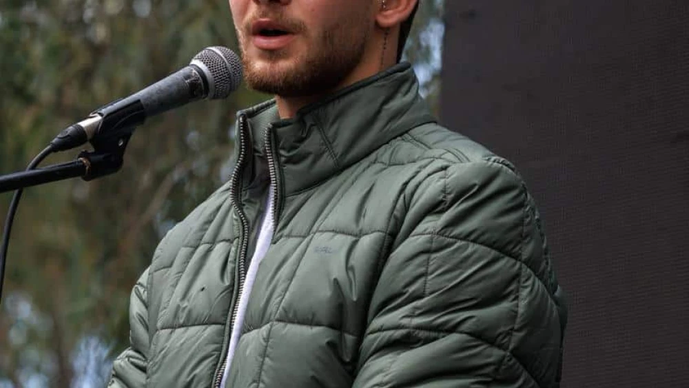Former Hamas captive Itay Regev speaks at the memorial ceremony on Jan. 5, 2024. Credit: Courtesy of the Hostages and Missing Families Forum HQ.