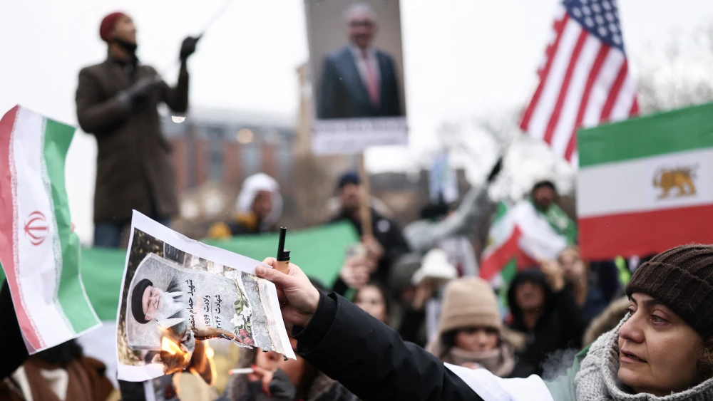 A woman burns a photo of Iranian Supreme Leader Ali Khamenei, as people sing and shout during a rally in support of the Iranian people in New York, Jan. 18, 2026. Protests in Iran have subsided after a crackdown that has killed thousands, monitors said on Jan. 16, a week after the start of the largest demonstrations in years challenging the country's theocratic system. Photo by Charly Triballea/AFP via Getty Images.