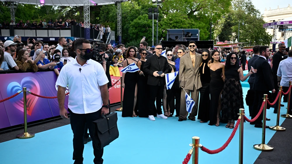 Israeli singer Noam Bettan, representing Israel with the song 'Michelle', surrounded by security, poses for photographers on the turquoise carpet for the opening ceremony of the Eurovision Song Contest 2026 at the City Hall Square in Vienna, Austria, on May 10, 2026. Credit: Tobias Schwarz/AFP via Getty Images.