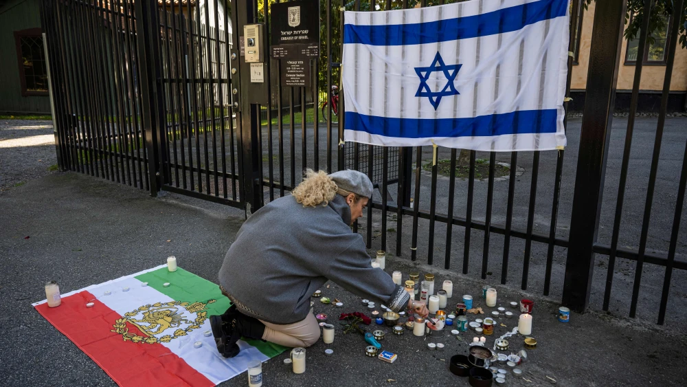 A woman lights a candle to show her solidarity and support outside the Israeli embassy in Stockholm, Sweden, on October 9, 2023, after the surprise attack by Hamas against Israel. Photo by JONATHAN NACKSTRAND/AFP via Getty Images.