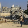 Palestinians walk past buildings destroyed in the recent war, in the Jorat al-Luth area, located between Rafah and Khan Yunis in the southern Gaza Strip, November 10, 2025. Photo by Abed Rahim Khatib/Flash90.
