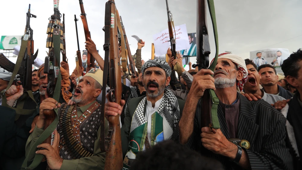 Armed protesters brandish their weapons and placards during a demonstration against a Saudi-led coalition in Sanaa, Yemen, on July 31, 2026. Photo by Mohammed Huwais/AFP/Getty Images.