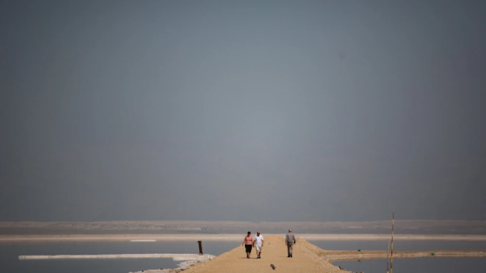 People walk on a sand barrier in the southern Dead Sea, on Feb. 21, 2017. Photo by Hadas Parush/Flash90.