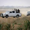 Palestinian terrorists of the Ezzedine al-Qassam Brigades, Hamas' armed wing, sit in the back of a pick-up truck watching Israeli bulldozers working along a barbed wire fence that separates Khan Yunis in the southern Gaza Strip and the Israeli border, on June 10, 2015. Photo by Abed Rahim Khatib/Flash 90.