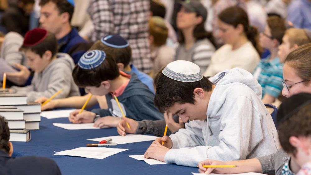 Students write feverishly at Chidon HaTanakh at Manhattan Day School. Photo by David Khabinsky.