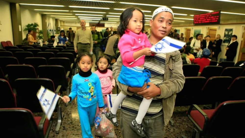 Newly arrived immigrants from India, members of the Bnei Menashe community, hold Israeli flags as they arrive at Ben-Gurion Airport, Nov. 21, 2006. Photo by Nati Shohat/Flash90.
