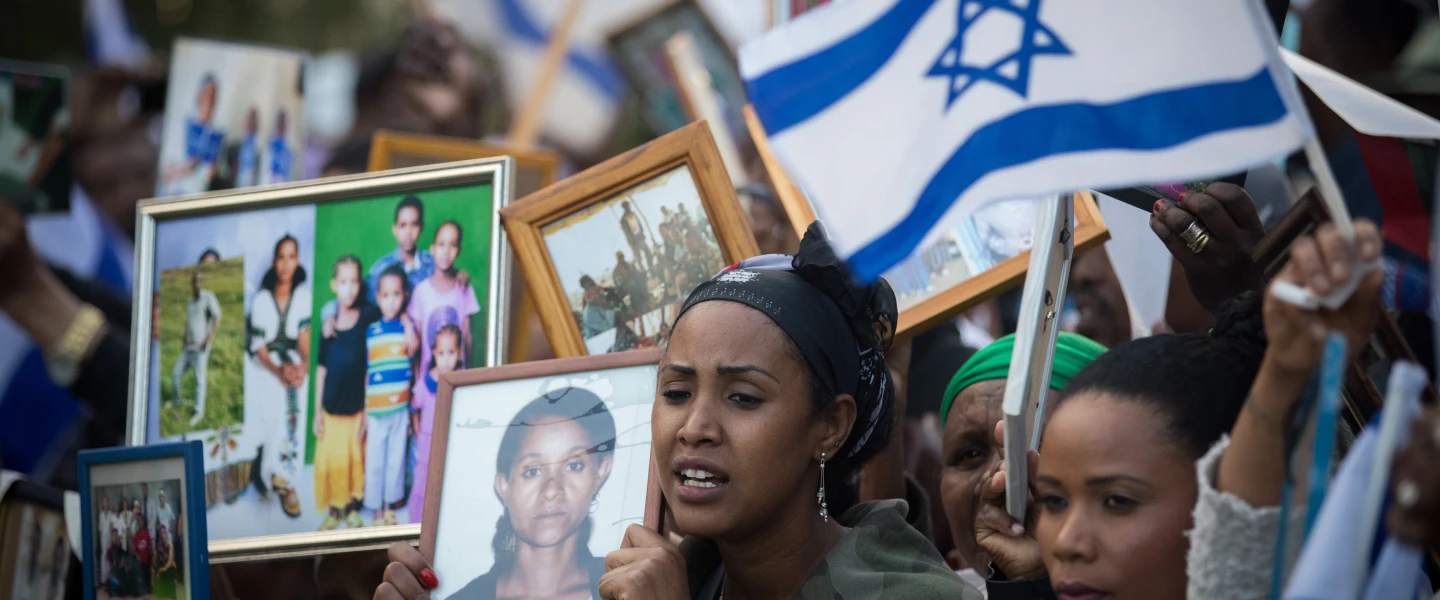Israelis who immigrated from Ethiopia hold up family photos of loved ones who remain in Ethiopia during a protest to bring the rest of the Falash Mura in Jerusalem, on March 12, 2018. Credit: Yonatan Sindel/Flash90.