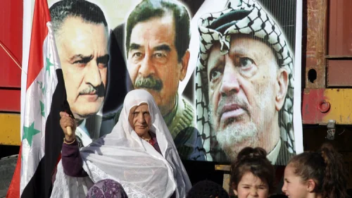Palestinians commemorate the third anniversary of the death of Saddam Hussein during a rally in the town of Halhoul near Hebron on Jan. 15, 2010. Next to the picture of Hussein (center) is a photo of late Palestinian leader Yasser Arafat. Credit: Najeh Hashlamoun/Flash90.