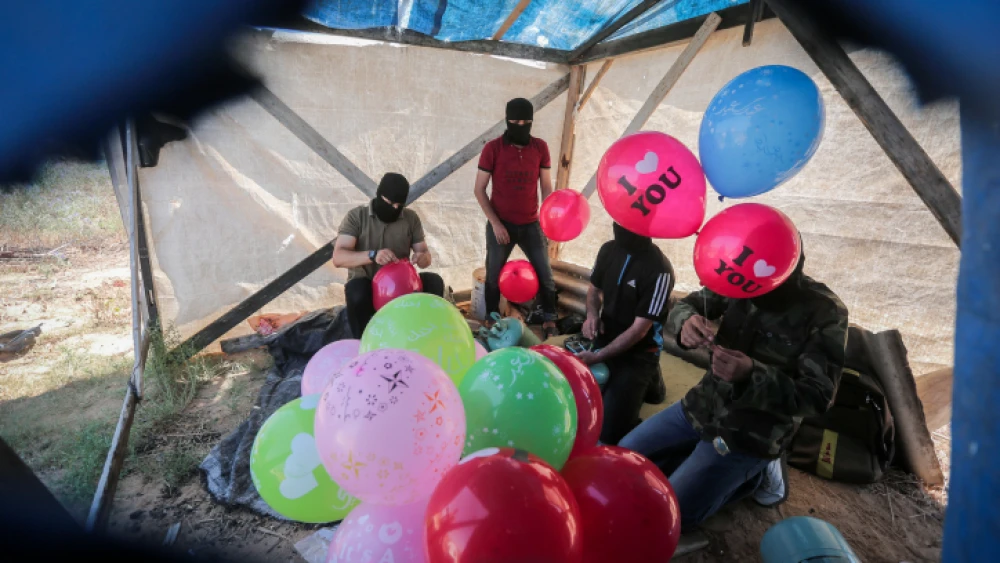 Palestinians prepare balloons that will be attached to flammable material to be launched into Israel from the Gaza Strip, on June 25, 2019. Photo by Hassan Jedi/Flash90.