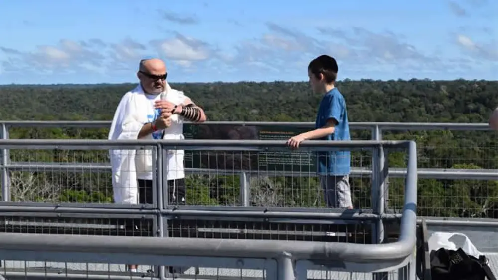 Putting on tefillin with the vast Amazon rainforest in the background. Credit: Chabad.org/News.