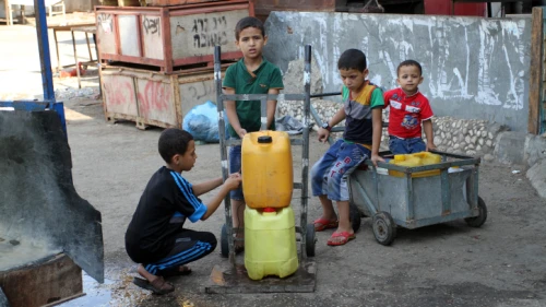 Palestinians fill plastic bottles with drinking water from a public tap in the southern Gaza Strip refugee camp of Rafah, on July 26, 2015. Photo by Abed Rahim Khatib/Flash 90.