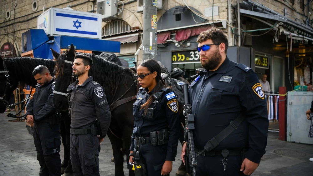 People stand still in outside the Mahane Yehuda Market in Jerusalem, as a two-minute siren is sounded across Israel to mark Holocaust Remembrance Day on April 24, 2025. Photo by Arie Leib Abrams/Flash90.