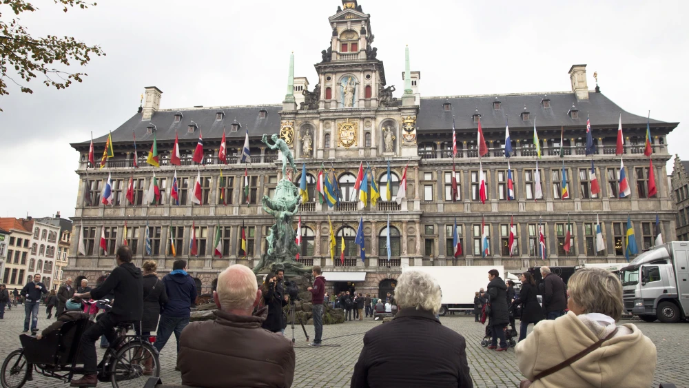 People sit in front of the Antwerp City Hall ahead of the election results on the day of the Belgian municipal and provincial elections, in Antwerp, on October 14, 2012. Photo credit: KRISTOF VAN ACCOM/AFP/GettyImages.