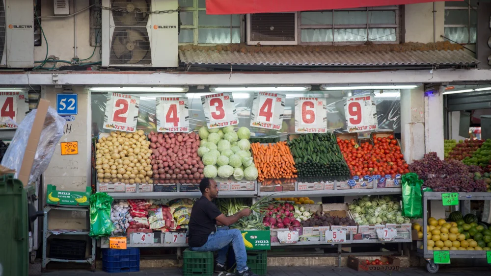 A young African man cleans vegetables at a grocery store in south Tel Aviv, on Nov. 01, 2017. Photo by Miriam Alster/Flash90.