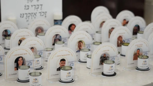 Memorial candles in front of images of the fallen at the OneFamily Passover weekend. Photo by Meir Pavlovsky.