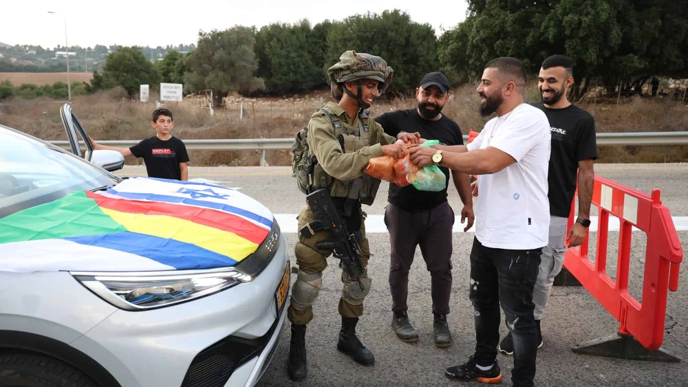 Druze Israelis hand out food to soldiers standing guard on a road near the border with Lebanon, Oct. 9, 2023. Photo by David Cohen/Flash90.