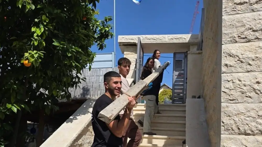 Volunteers assist residents of Beit Shemesh impacted by the March 1 Iranian ballistic missile attack on the city, March 12, 2026. Credit: Shir Goren.