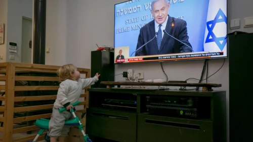 A child watches as Israeli Prime Minister Benjamin Netanyahu holds a live press conference on the new government restrictions for the public regarding the COVID-19 crisis on March 19, 2020. Photo by Chen Leopold/Flash90.
