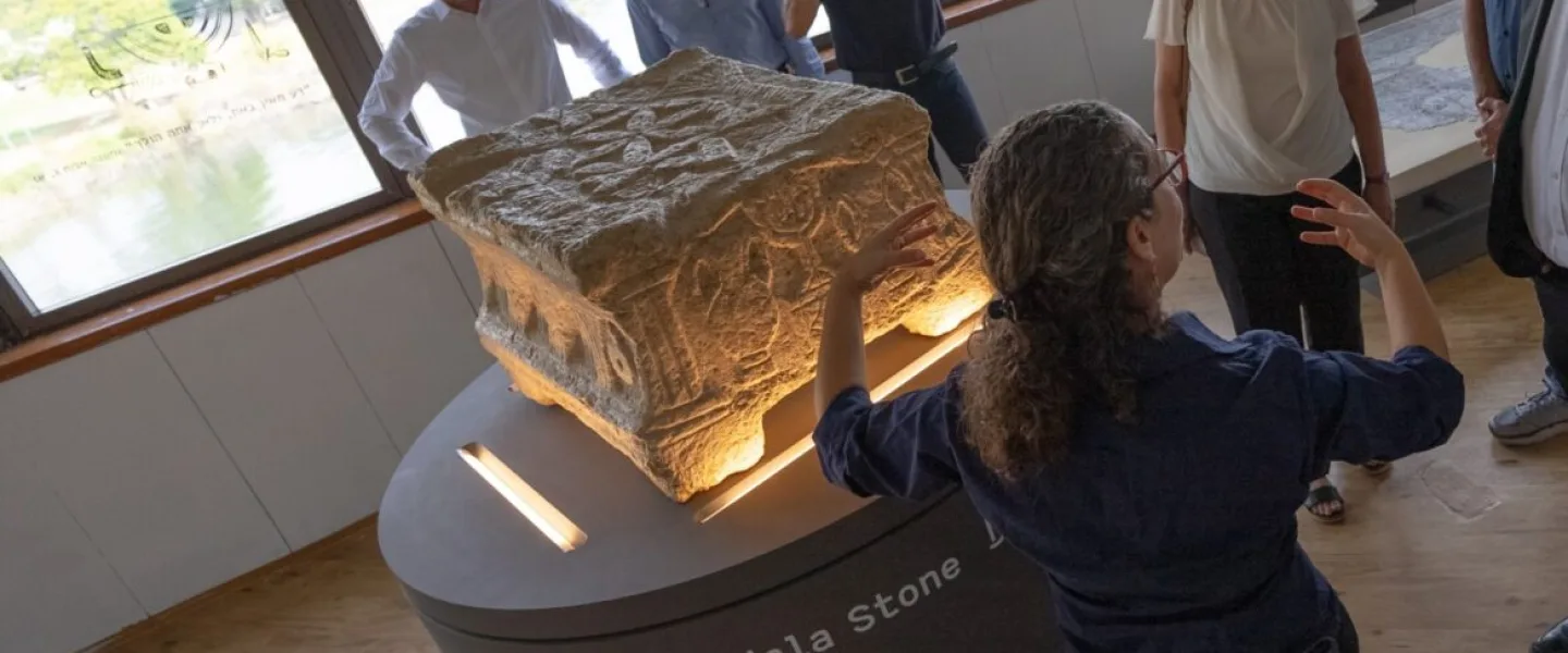Einat Ambar Armon, curator of the Sanhedrin Trail exhibition on behalf of the Israel Antiquities Authority, presents the Magdala Stone. Photo by Yair Amitzur/Israel Antiquities Authority.