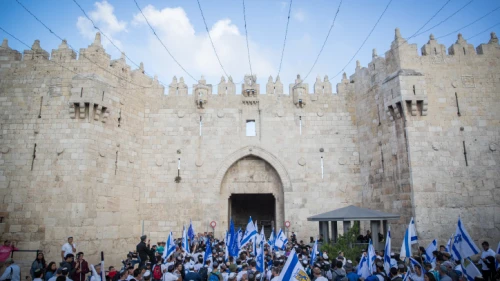 Thousands wave Israeli flags as they celebrate “Jerusalem Day” by dancing through Damascus Gate on their way to the Western Wall. May 13, 2018. Photo by Yonatan Sindel/Flash90.