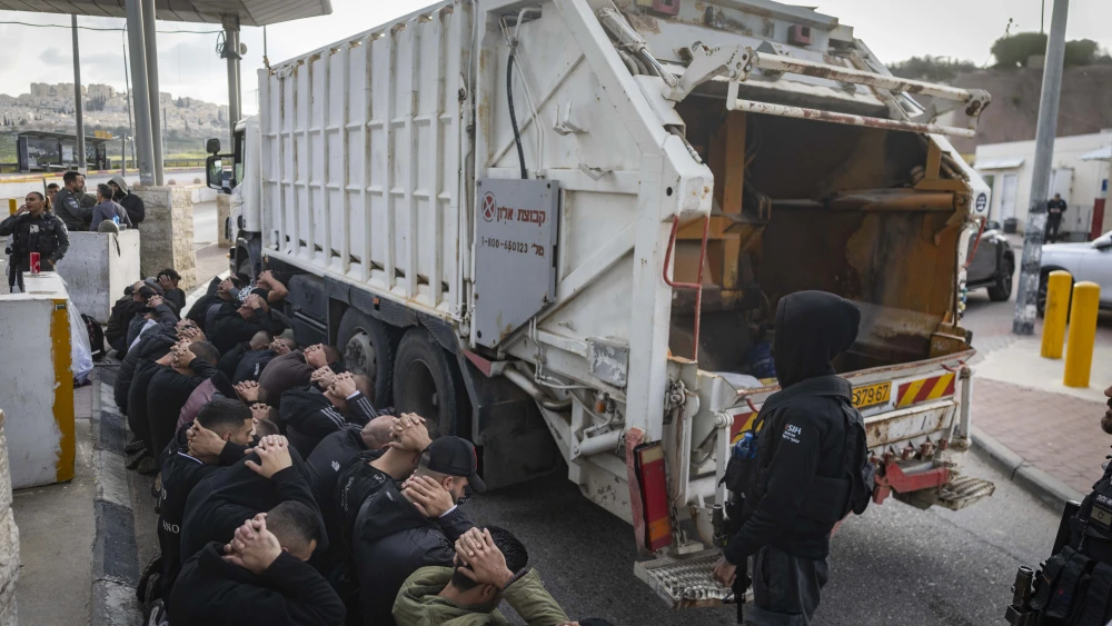 Israeli Border Police officers detain Palestinians who attempted to enter Israel illegally after hiding inside a rubbish truck, at the al-Za’im checkpoint north of Jerusalem, March 23, 2026. Photo by Chaim Goldberg/Flash90.
