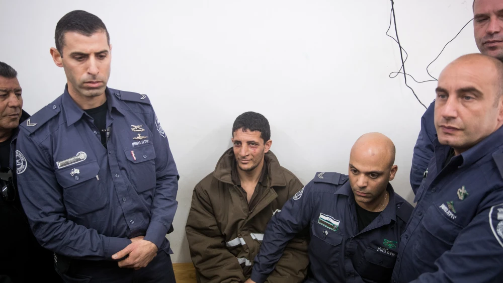 Police escort a Palestinian charged with the murder of 19-year-old Ori Ansbacher, at the Jerusalem Magistrate's court, on Feb. 11, 2019. The suspect was captured hiding in Ramallah after Israeli forces investigated the scene where the young woman was found dead last week in Ein Yael, in the outskirts of Jerusalem. Photo Yonatan Sindel/Flash90.