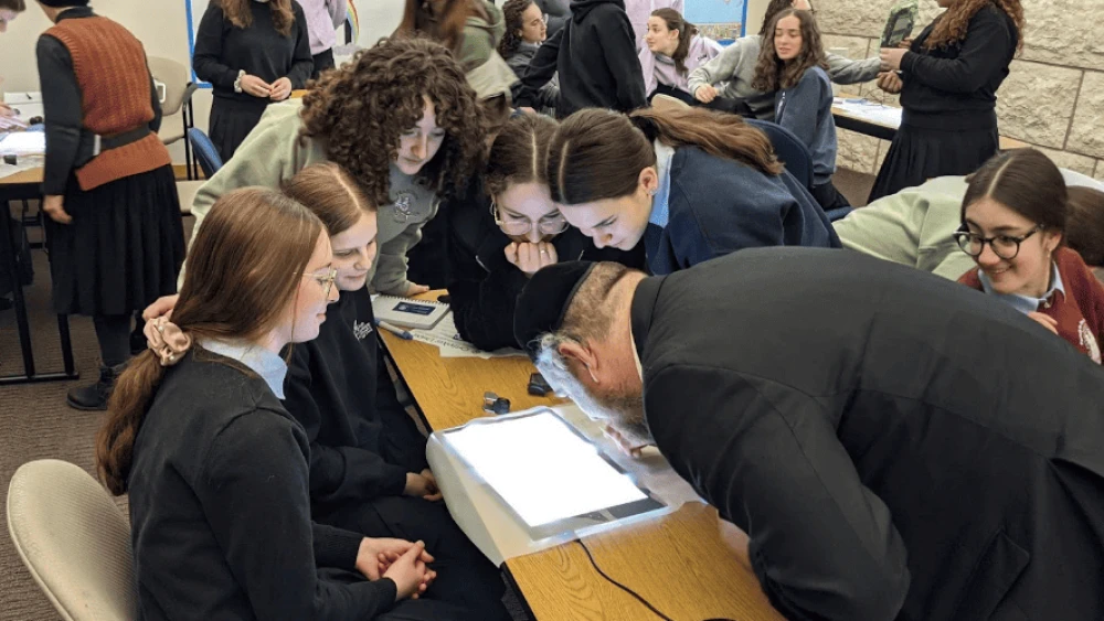 OU Kosher Rabbinic Coordinator Rabbi Daniel Sharrat demonstrates the process of bedikas tolayim (checking for insect infestation) at Torah Academy of Milwaukee (TAM). Credit: Courtesy.