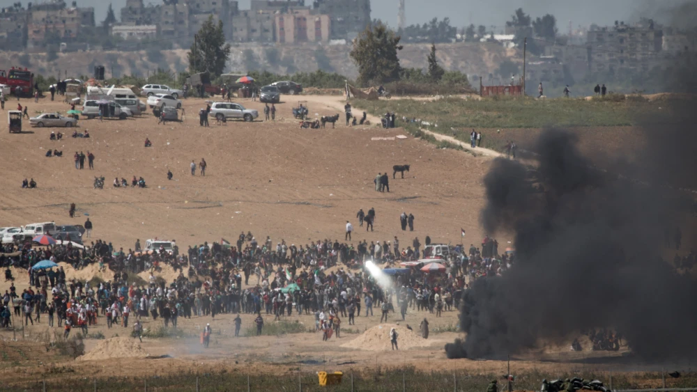 Palestinian protesters attempt to blind Israel Defense Forces with mirrors, as they demonstrate and burn tires near the border with Israel in the Gaza Strip, as seen from the Israeli side of the border on April 6, 2018. Credit: Hadas Parush/Flash90