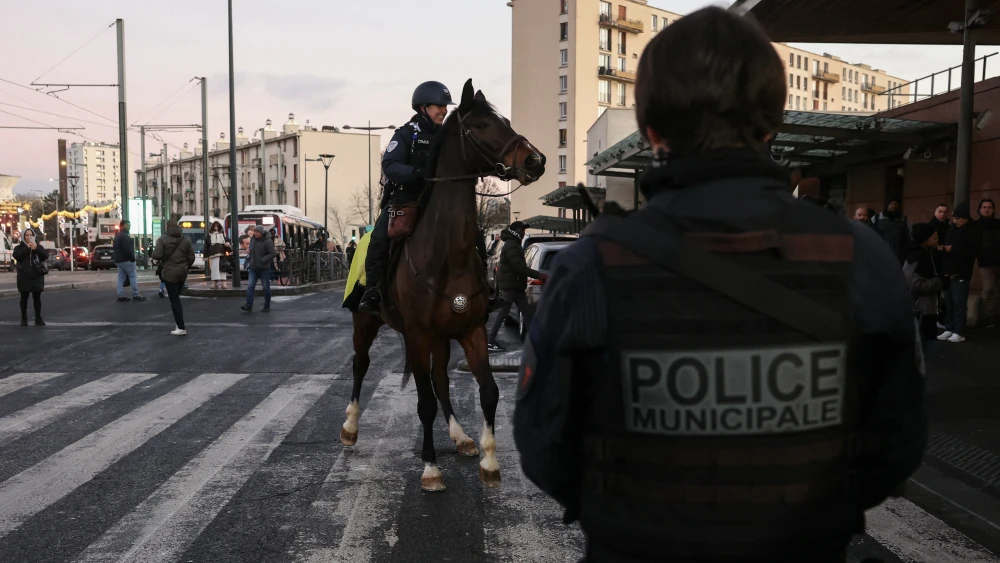 Municipal police and a mounted police officer patrol outside Garges-Sarcelles train station ahead of New Year's Eve, in Garges-les-Gonesse, a suburb of Paris, on December 31, 2025. Photo by Alain Jocard/Pool/AFP via Getty Images.