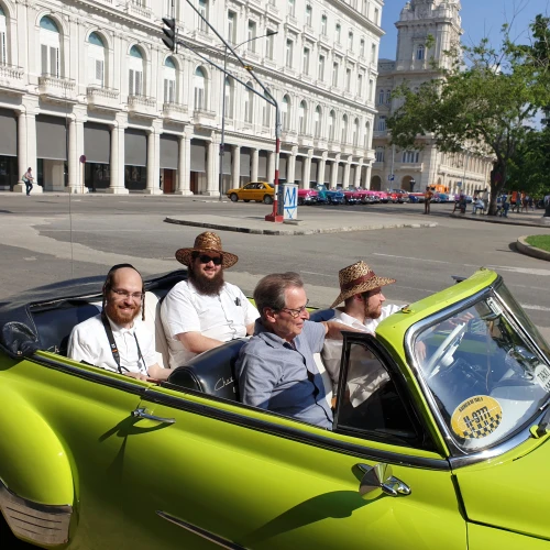 Saul Berenthal (front left), 75, was born and raised in Cuba but left for Miami in 1960, following the 1959 Castro revolution. He is pictured here in Havana, cruising around in a classic 1950s American-made car. Credit: Courtesy.