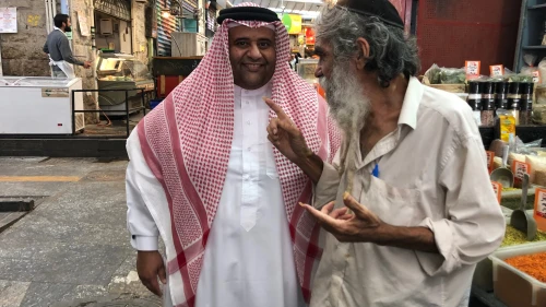 A Bahraini chats with an Israeli at Jerusalem's Machane Yehuda market, October 2021. Photo by Josh Hasten.