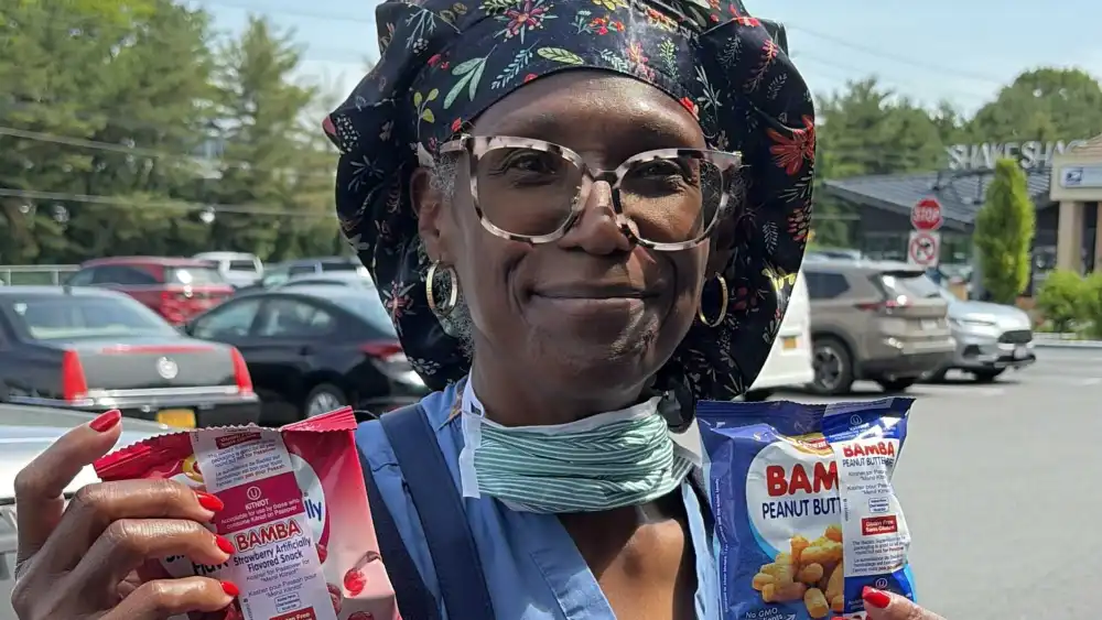 A woman holds up free bags of strawberry- and peanut butter-flavored Bamba, a popular Israeli snack food, handed out by Jewish and pro-Israel supporters, aka IMPACT Snack Crews. Credit: Courtesy of IMPACT.
