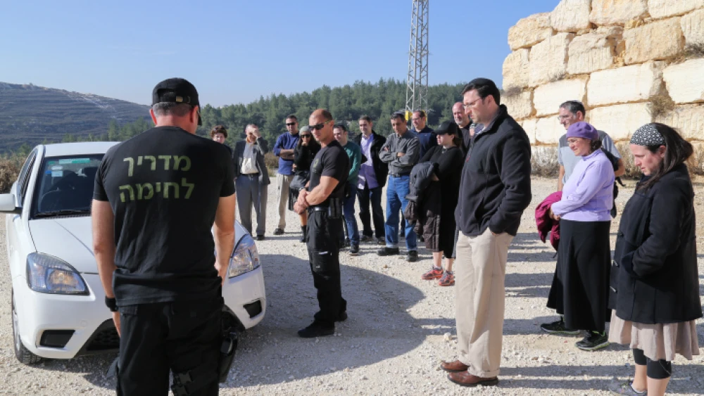 An firearms instructor trains a group how to respond if their cars are stoned, at a shooting range in Gush Etzion. November 30, 2014. Photo by Gershon Elinson/Flash90.