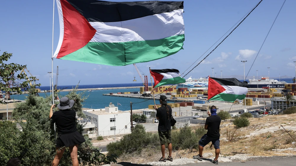 Pro-Palestinian demonstrators hold Palestinian flags, as they take part in a demonstration against the arrival of Israeli cruise passengers in Heraklion Port, on the island of Crete, on August 28, 2025. Photo by Costa Metaxakis/AFP via Getty Images.