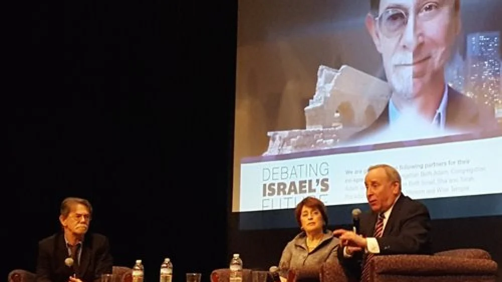 J.J. Goldberg (left) and Jonathan Tobin (right) during one of their debates, in Cincinnati, with a split-screen graphic of their faces on the projector in the background. Credit: Courtesy of J.J. Goldberg/Jonathan Tobin debate tour.