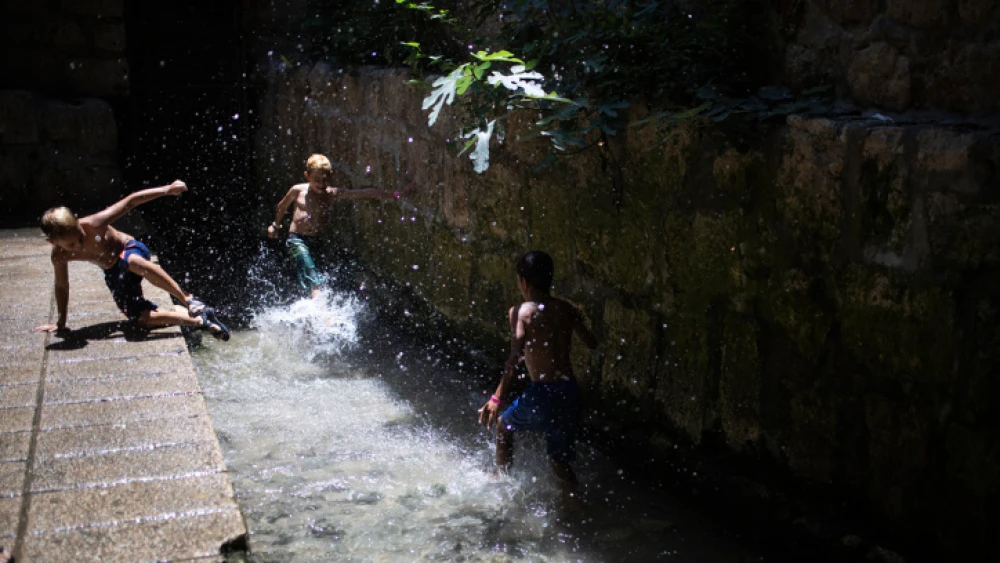 Young Israeli boys on their summer vacation play in the water of the Siloam Pool after walking through Hezekiah's Tunnel during a visit to the City of David National Park, on July 21, 2019. Photo by Hadas Parush/Flash90.