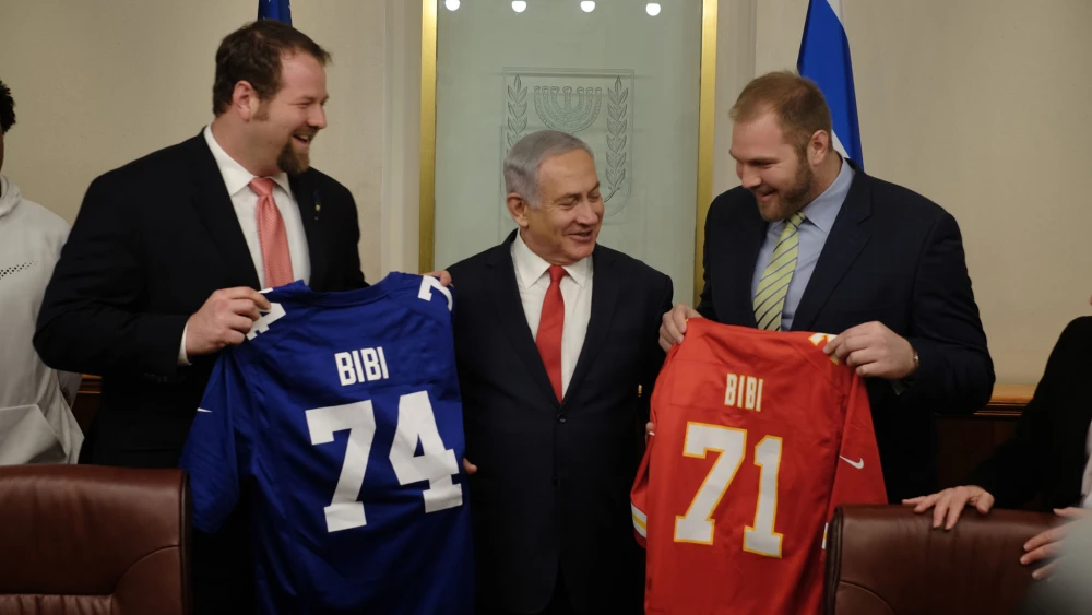 Jewish NFL football players and brothers Geoff (left) and Mitchell Schwartz present Israeli Prime Minister Benjamin Netanyahu with football jerseys that have his nickname, "Bibi," on them in his Jerusalem office on Feb. 19, 2018. (Judah Ari Gross/Times of Israel)