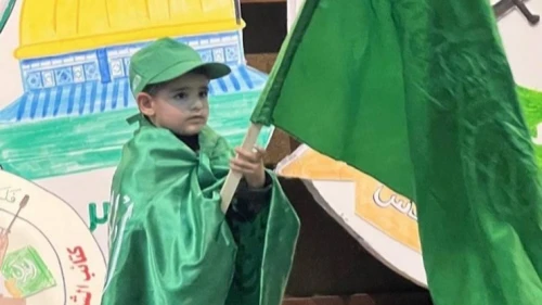 A boy holds a Hamas flag at the Al-Quds University event on Dec. 11, 2022. Source: T.me/kotlaalquds via MEMRI.