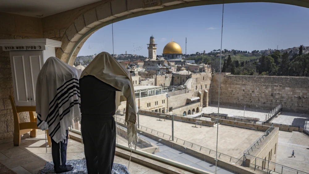 Jews pray inside an apartment overlooking the Western Wall plaza in Jerusalem’s Old City during the Passover holiday on April 6, 2026, as the plaza remains closed for prayer due to the ongoing war. Photo by Yonatan Sindel/Flash90.
